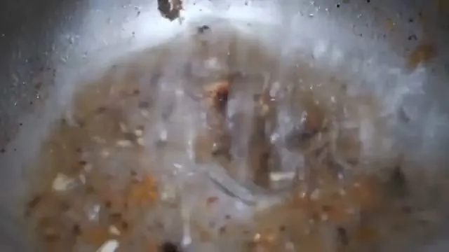 Close view of the inside of a pipe with brown deposits and water