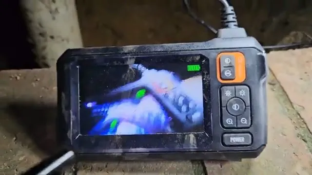 Handheld inspection camera screen displaying the inside of a pipe