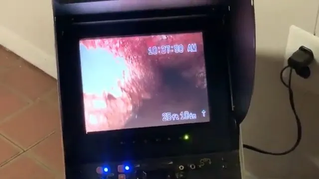 Plug-in camera monitor displaying the red-tinted inside of a pipe with a distance reading